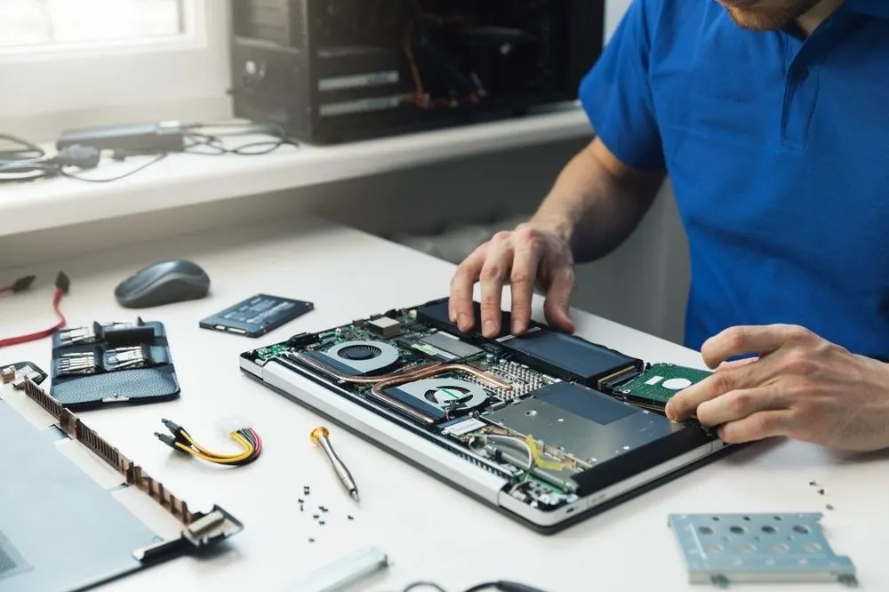 Matt repairing a laptop's internals during an in-home visit